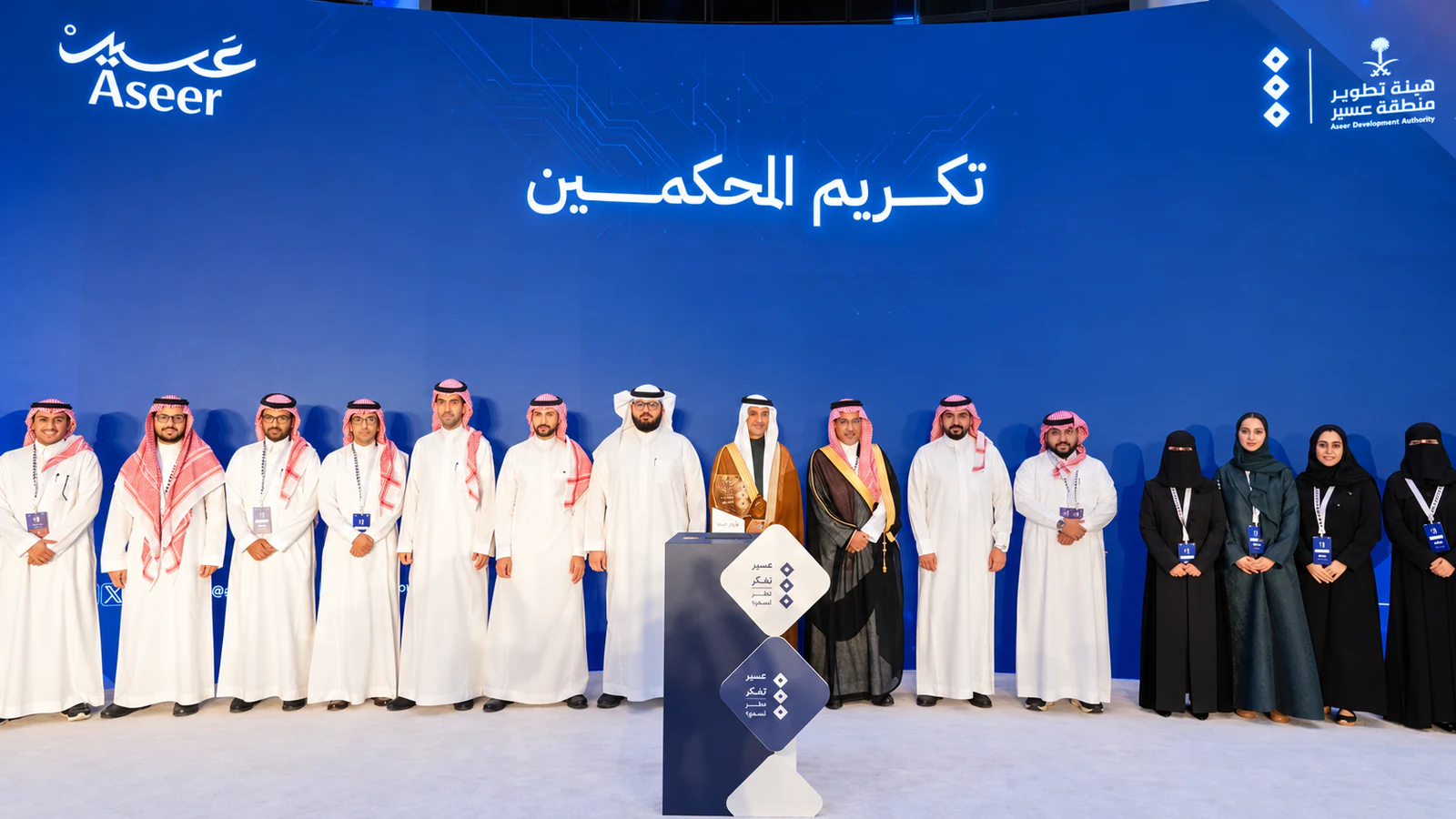 صورة جماعية للمحكمين تحت لافتة تكريم المحكمين