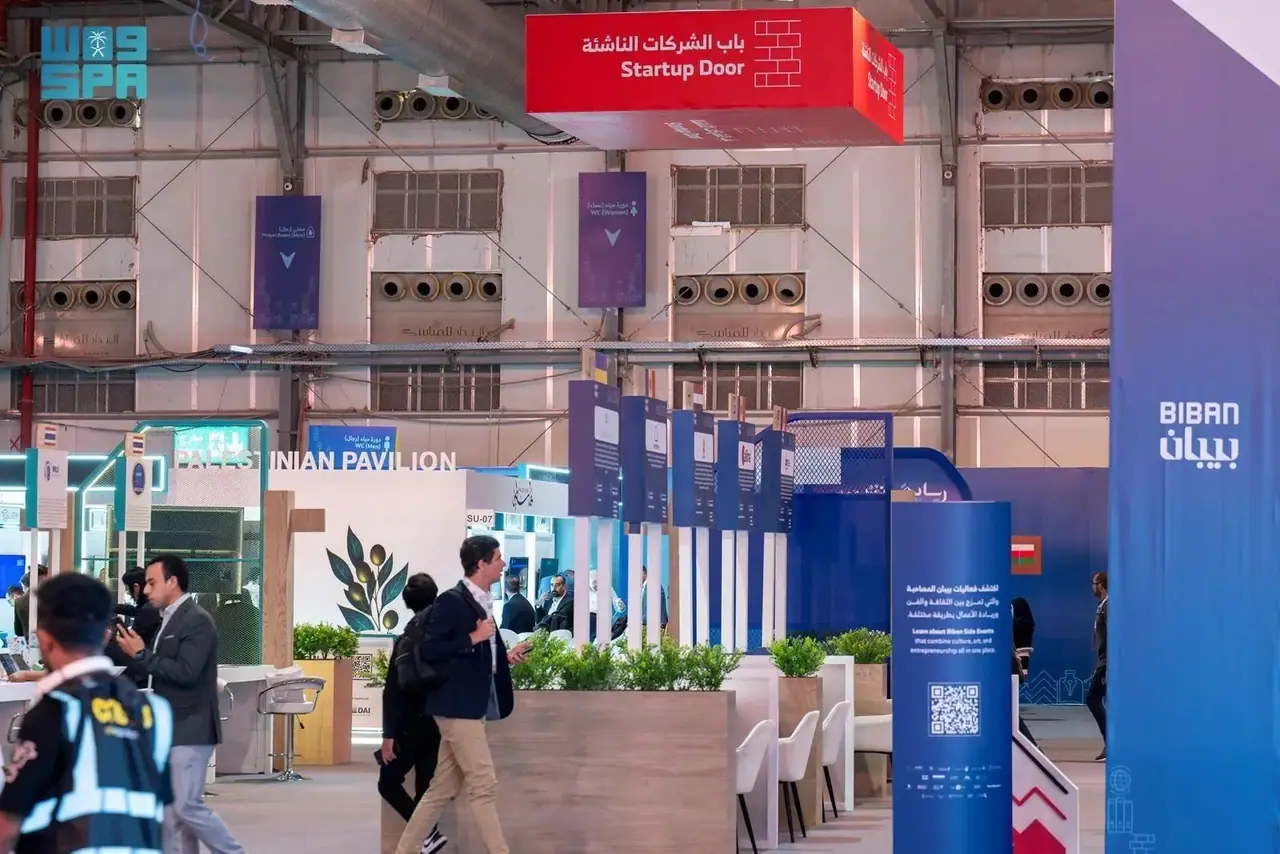 Visitors walk through the Biban 2025 exhibition hall beneath a red Startup Door sign